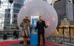 ޑިކް ކްލާކްސް ނިއު އިޔާސް ރޮކިން އީވް ވިތް ރަޔަން ސީކްރެސްޓް 2026" ގެ ހުށަހެޅުންތެރިން ކަމަށްވާ ރަޔަން ސީކްރެސްޓް އަދި ރީޓާ އޮރާ، ނިއު ޔޯކް ސިޓީގެ ޓައިމްސް ސްކޮޔަރގައި ބޭއްވުނު އާ އަހަރު ފާހަގަކުރުމުގެ ހަރަކާތްތަކުގެ ތެރެއިން، އެ ސަރަޙައްދުގައި ހުންނަ މަޝްހޫރު ބޯޅަ (ball) ކައިރިން ފެނިގެންދަނީ.[ފޮޓޯ: ޓެޑް ޝެފްރީ / އޭޕީ] 